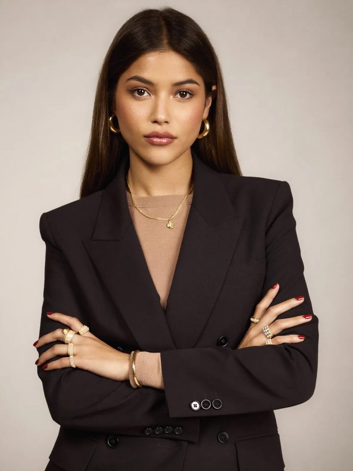 Advogada de blazer preto em fundo claro de estúdio